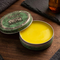 Reuzel Green Grease Medium Hold Pomade - open blik met gele pomade op hout