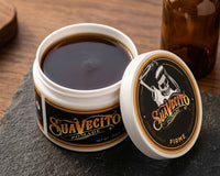 Suavecito Firme Hold Pomade - open pot met donkere textuur op leisteen