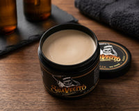 Suavecito Matte Pomade - open pot met lichte matte textuur op hout