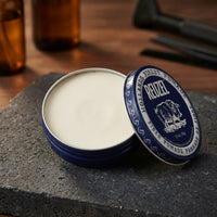 Reuzel Fiber Pomade - open blik met matte inhoud op leisteen, barbertools