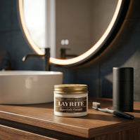 Layrite Superhold Pomade - pot op houten meubel bij ronde spiegel
