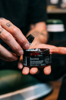 Bullfrog Strong Adhesion Matte Wax - hand tilt deksel van open pot in barbershop