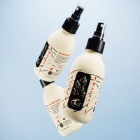 By Elementum Aura Sea Salt Spray - twee zwevende spuitflessen tegen lichtblauwe achtergrond