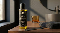 Bone Crusher Haarolie - fles op wastafelblad naast glas whisky en kam