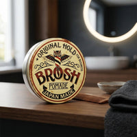 BROSH Original Pomade - gesloten blik rechtop op kaptafel met spiegel en handdoek