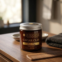 JS Sloane Caviar Clay - potje Heavy Hold op houten tafel met kam