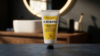 Layrite Concentrated Beard Oil - staande tube op donker blad bij wastafel