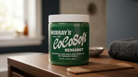 Murrays Cocosoft Bergamot - groene pot op houten meubel met kam en handdoek
