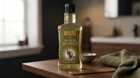 Reuzel 3-in-1 Tea Tree Shampoo 350ml - fles op tafel met kam en handdoek